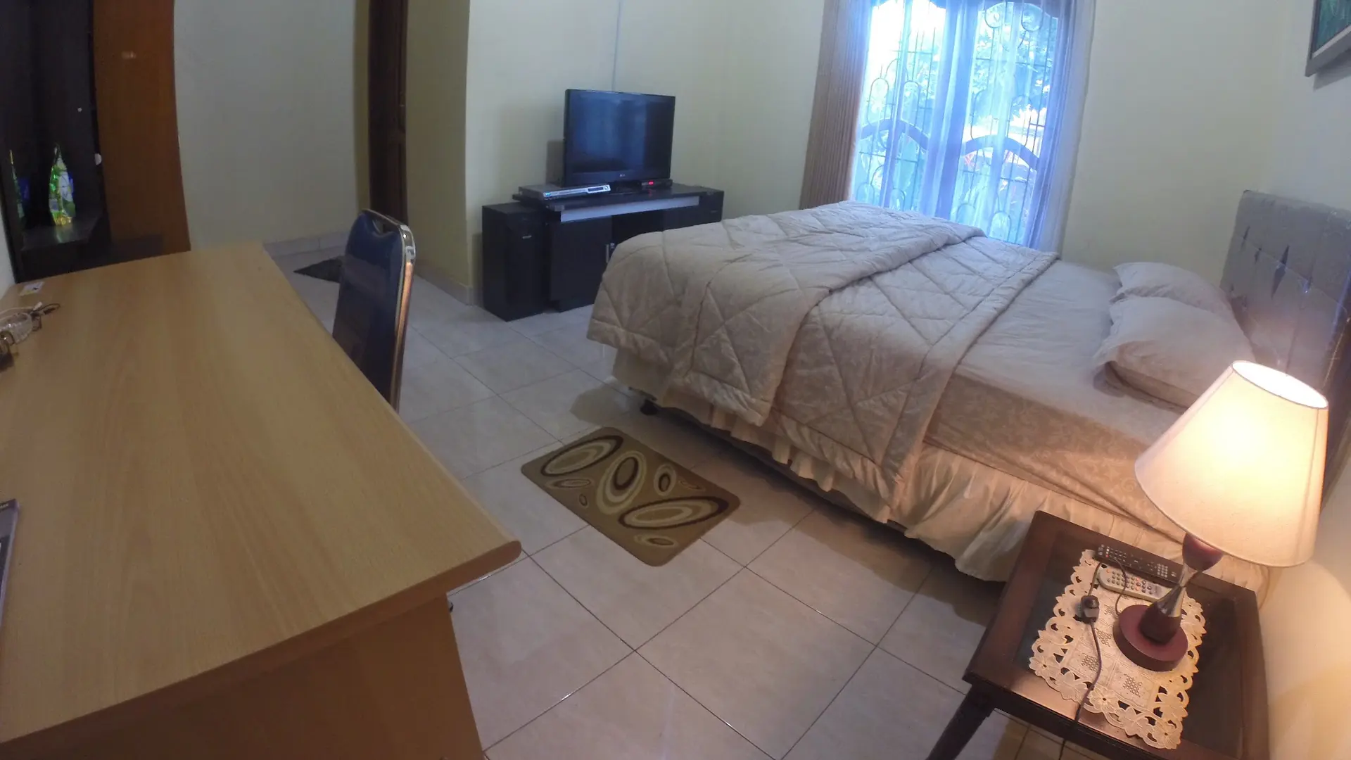 Guest bedroom with a bed, desk and air conditioning