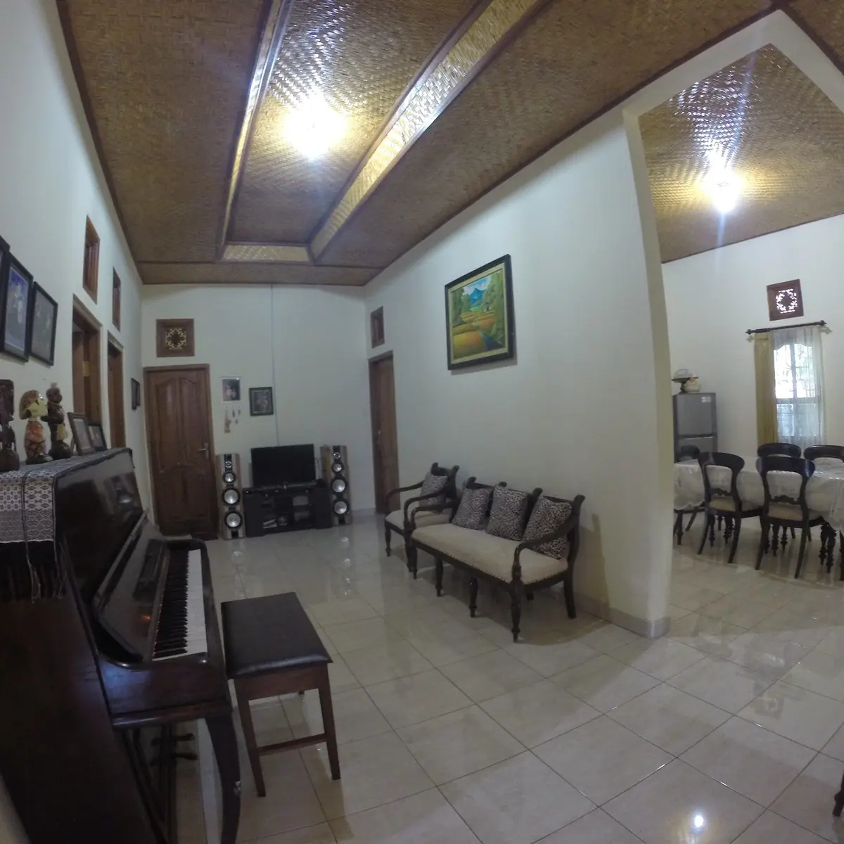 Family room with a piano, sofa and dining table