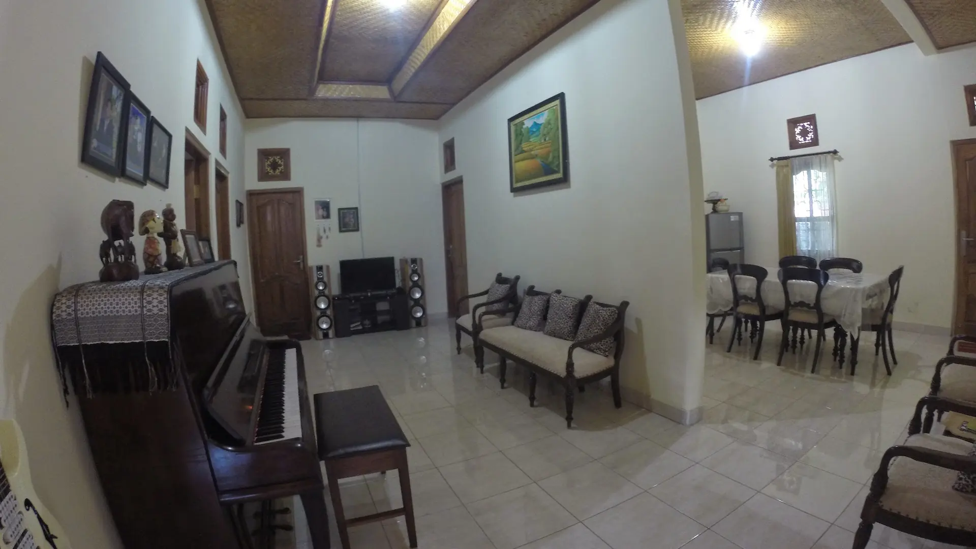 Family room with a piano, sofa and dining table