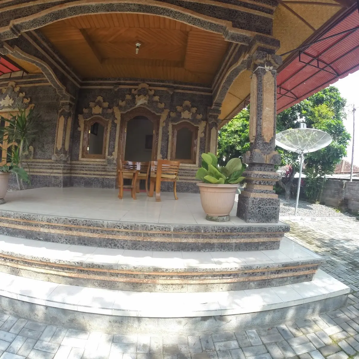 Raised terrace with carved columns and a small seating area